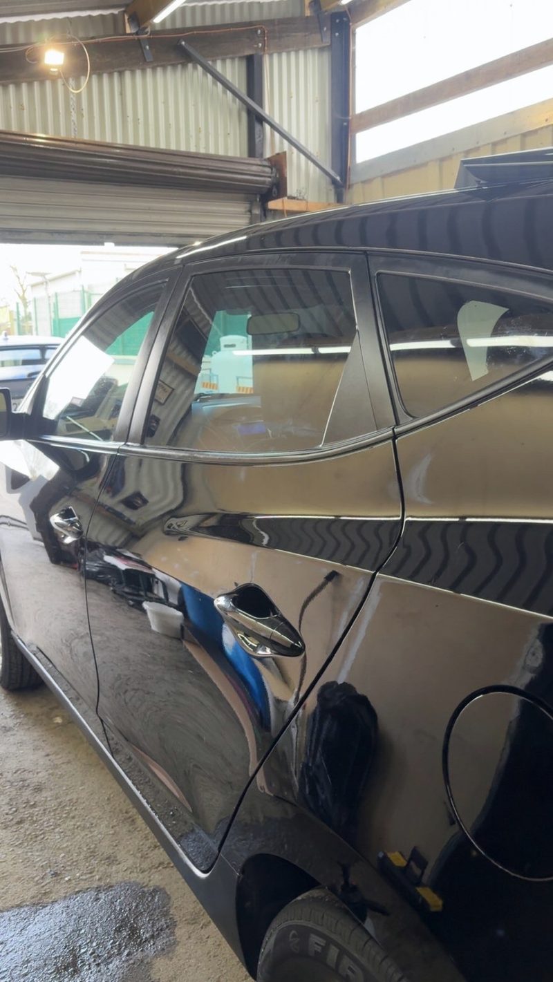 Black hatchback, rear doors, in the unit