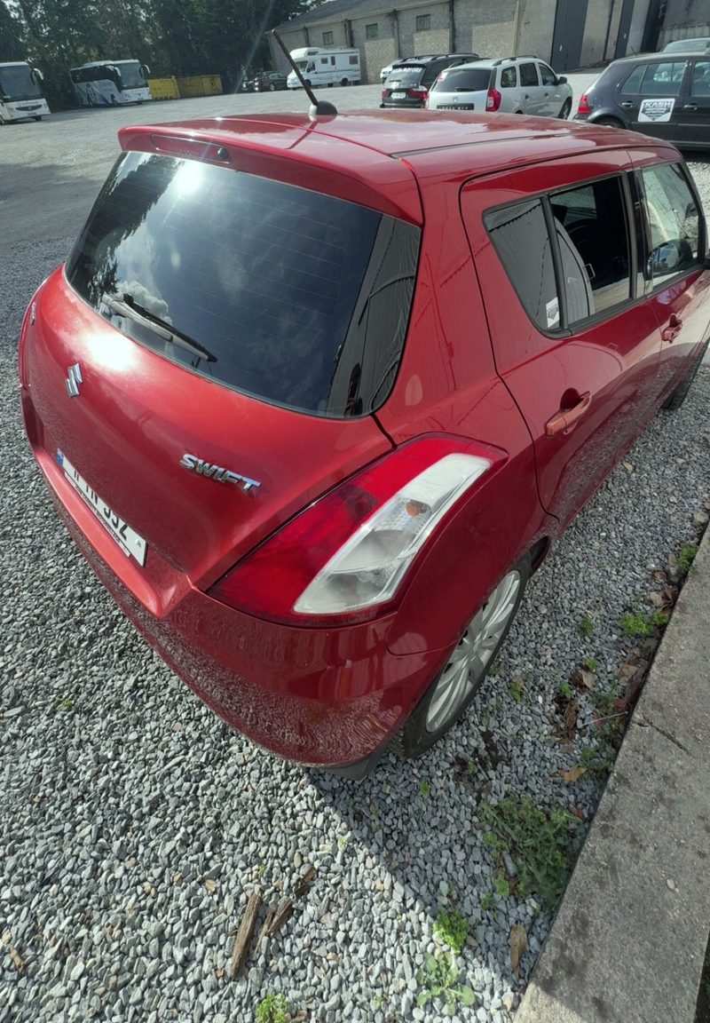 Red Suzuki Swift, back three windows, 20%